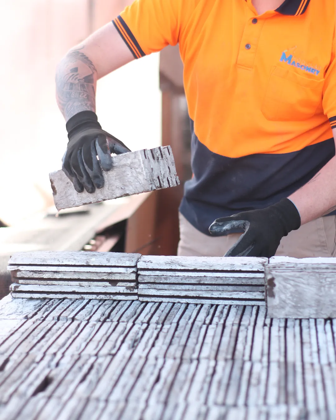 Modular Masonry worker cutting and processing clay brick facings on the workshop bench